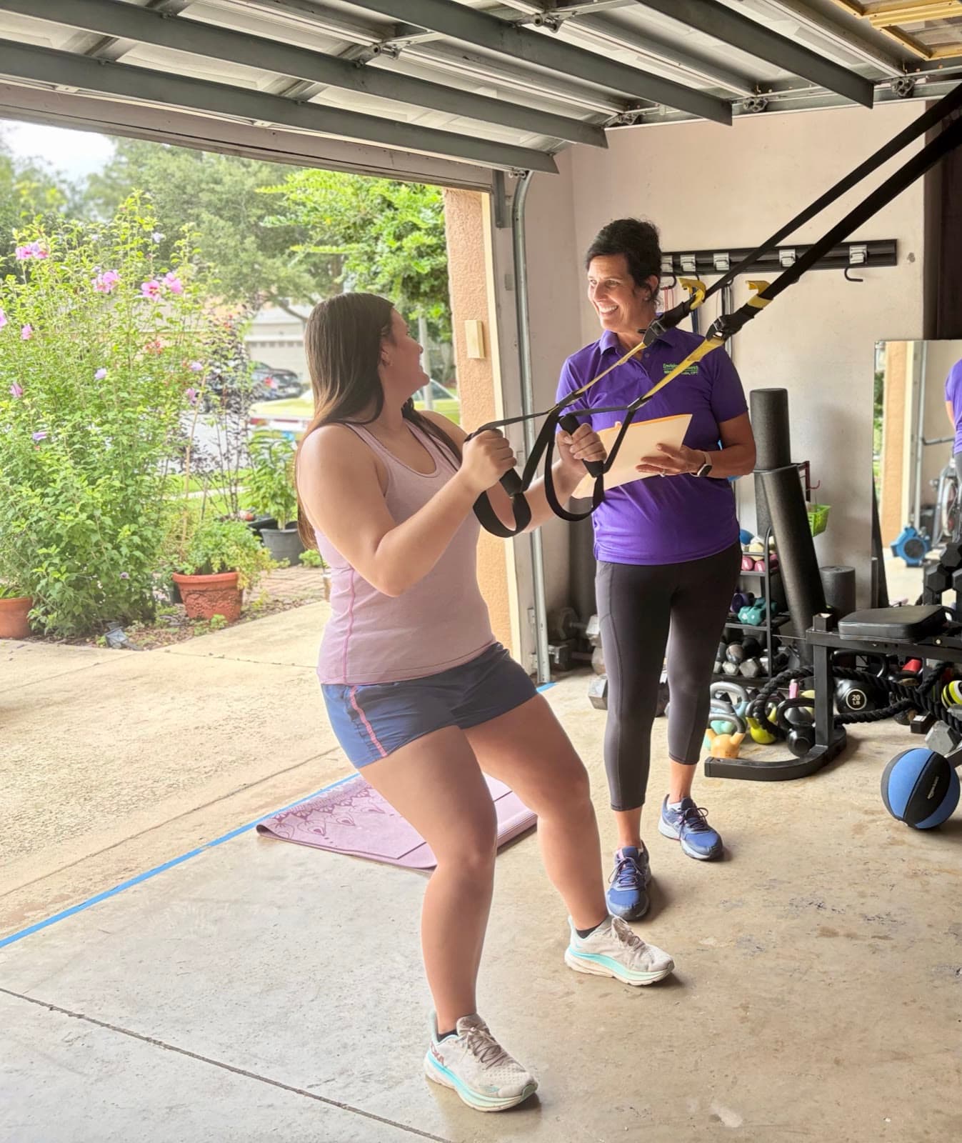 Nikki Van Culin coaching a client through a suspension-trainer row in her open garage studio